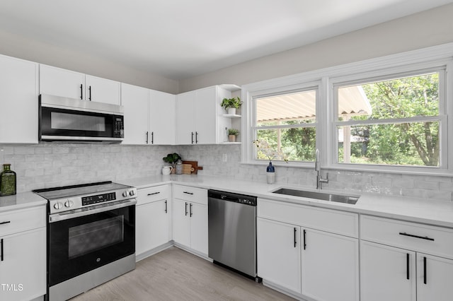 2003 Broadway Rd, Sanford, NC 27332 - kitchen featuring stainless steel appliances, a sink, light countertops, decorative backsplash, and white cabinetry