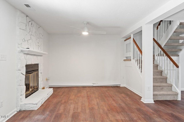 134 Luxon Pl, Cary, NC 27513 - unfurnished living room with wood finished floors, stairs, a ceiling fan, and a fireplace
