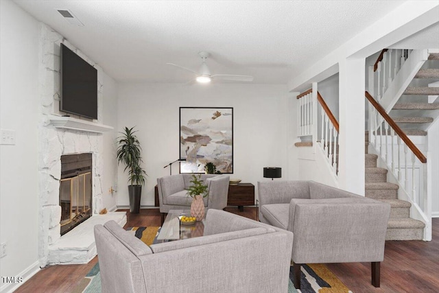 134 Luxon Pl, Cary, NC 27513 - living room with wood finished floors, stairway, a high end fireplace, and a ceiling fan