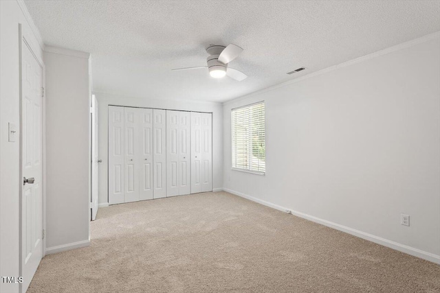134 Luxon Pl, Cary, NC 27513 - unfurnished bedroom with carpet, ornamental molding, a textured ceiling, a closet, and a ceiling fan