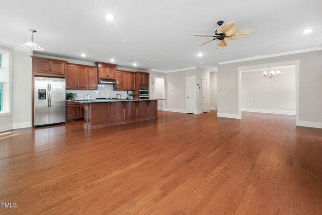 10310 Sablewood Dr Unit 111, Raleigh, NC 27617 - kitchen featuring stainless steel appliances, under cabinet range hood, a kitchen breakfast bar, crown molding, and an island with sink