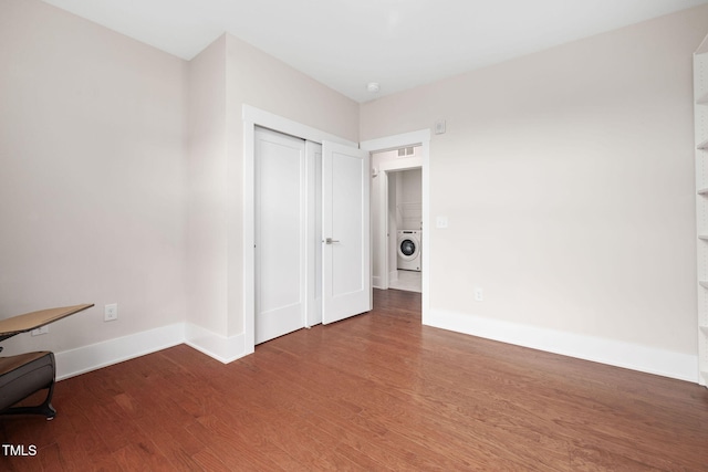 10310 Sablewood Dr Unit 111, Raleigh, NC 27617 - unfurnished bedroom featuring baseboards, wood finished floors, washer / clothes dryer, and a closet