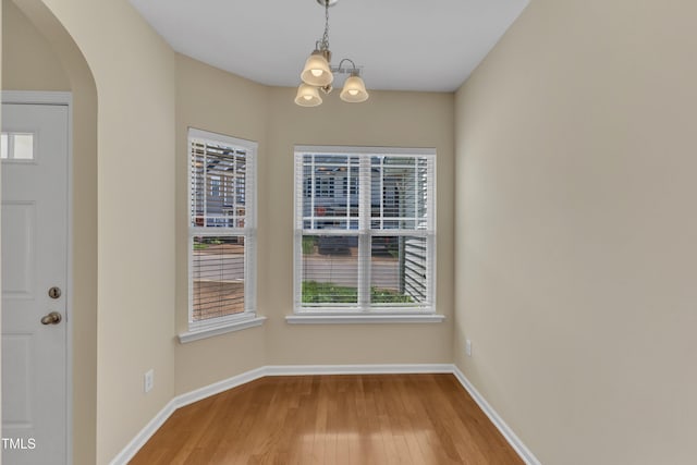 2513 Asher View Ct, Raleigh, NC 27606 - unfurnished dining area featuring a chandelier, healthy amount of natural light, and wood finished floors