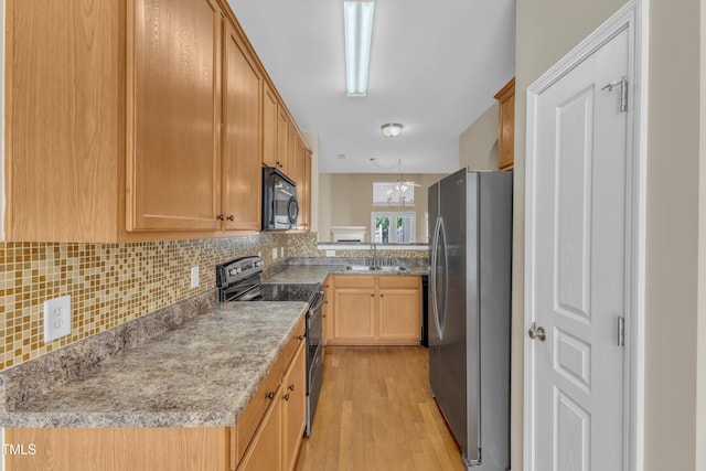 2513 Asher View Ct, Raleigh, NC 27606 - kitchen with appliances with stainless steel finishes, a sink, backsplash, light wood-style flooring, and a chandelier