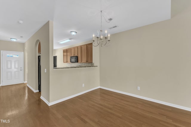 2513 Asher View Ct, Raleigh, NC 27606 - unfurnished dining area with a chandelier, dark wood-type flooring, arched walkways, and baseboards