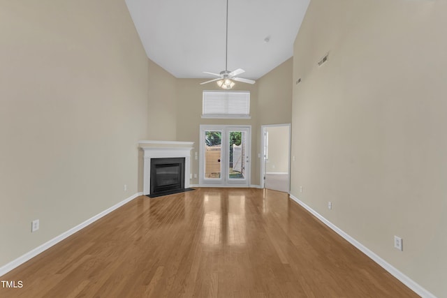 2513 Asher View Ct, Raleigh, NC 27606 - unfurnished living room with baseboards, a fireplace with flush hearth, high vaulted ceiling, light wood-style floors, and ceiling fan