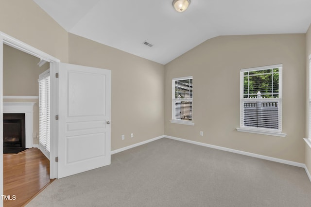 2513 Asher View Ct, Raleigh, NC 27606 - carpeted spare room with vaulted ceiling, a fireplace with flush hearth, and baseboards