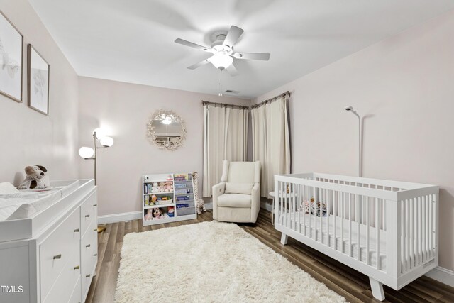 3821 La Costa Way, Raleigh, NC 27610 - bedroom with wood finished floors, baseboards, a crib, and ceiling fan