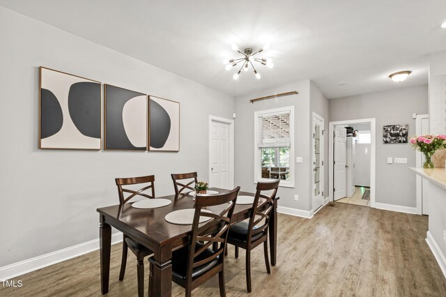 3821 La Costa Way, Raleigh, NC 27610 - dining space with a chandelier, wood finished floors, and baseboards