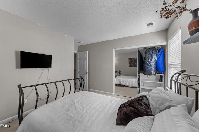 bedroom featuring carpet, baseboards, a closet, and a textured ceiling