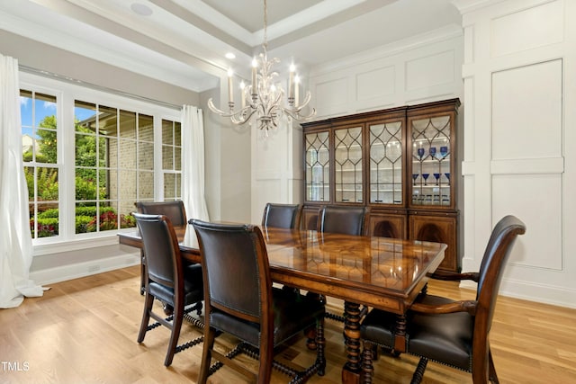 238 Michelangelo Way, Cary, NC 27518 - dining room featuring a chandelier, a decorative wall, light wood-style flooring, crown molding, and healthy amount of natural light