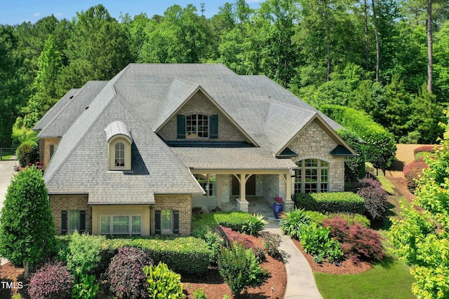 238 Michelangelo Way, Cary, NC 27518 - french country style house with stone siding, brick siding, a shingled roof, and a porch