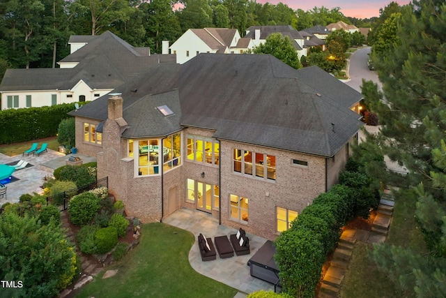 238 Michelangelo Way, Cary, NC 27518 - back of property featuring a patio, a chimney, a shingled roof, and brick siding