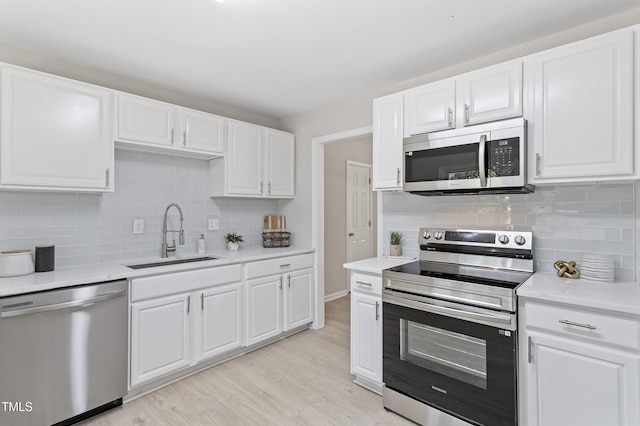 3204 Winfield Ct, Raleigh, NC 27610 - kitchen featuring stainless steel appliances, a sink, tasteful backsplash, light wood-type flooring, and light countertops