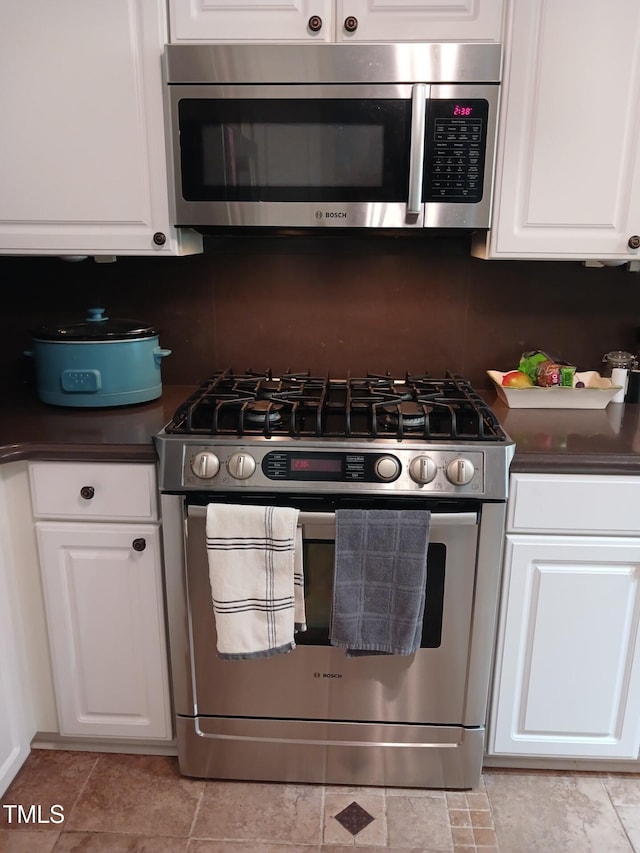 631 Springfork Dr, Cary, NC 27513 - kitchen with appliances with stainless steel finishes, dark countertops, decorative backsplash, and white cabinets