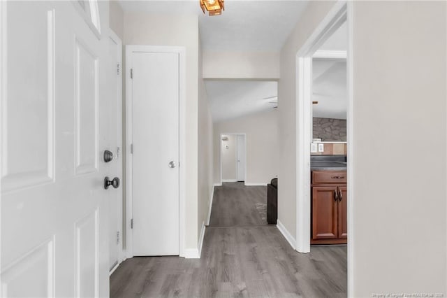 7076 Pantego Dr, Fayetteville, NC 28314 - hallway featuring light wood finished floors, lofted ceiling, and baseboards