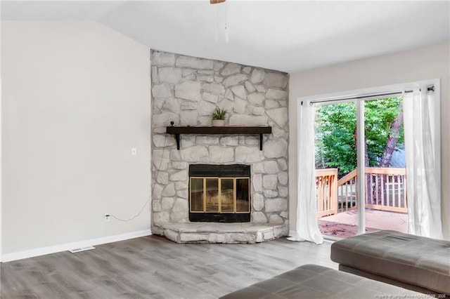 7076 Pantego Dr, Fayetteville, NC 28314 - living room featuring a stone fireplace, wood finished floors, vaulted ceiling, and baseboards