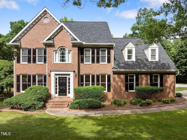 100 Silver Lining Ln, Cary, NC 27513 - colonial inspired home featuring brick siding, a front lawn, and roof with shingles