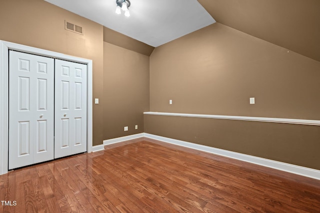 100 Silver Lining Ln, Cary, NC 27513 - unfurnished bedroom featuring vaulted ceiling, wood finished floors, baseboards, and a closet