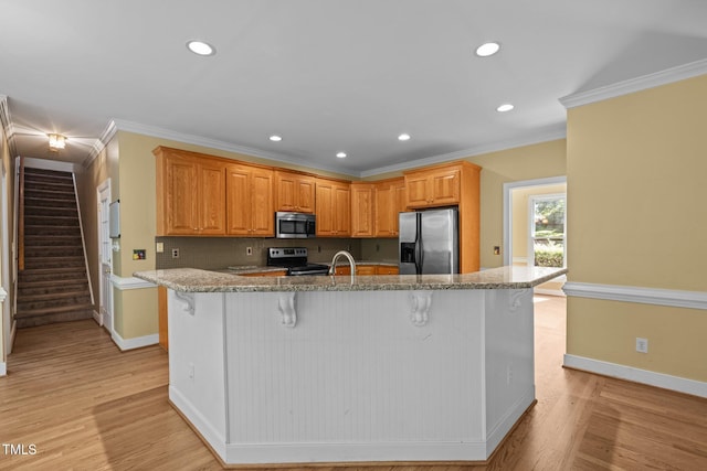 100 Silver Lining Ln, Cary, NC 27513 - kitchen featuring appliances with stainless steel finishes, baseboards, a kitchen bar, light stone counters, and recessed lighting