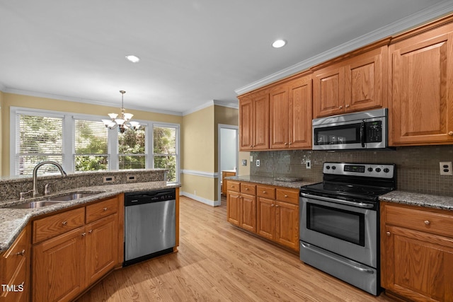 100 Silver Lining Ln, Cary, NC 27513 - kitchen featuring stainless steel appliances, a sink, a chandelier, ornamental molding, and brown cabinets