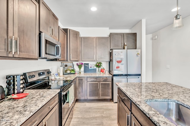 6760 Longitude Cir, Sims, NC 27880 - kitchen with stainless steel appliances, light wood-style flooring, light stone counters, decorative light fixtures, and recessed lighting