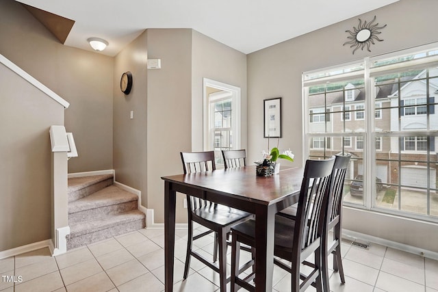 4907 Wyatt Brook Way, Raleigh, NC 27609 - dining space with light tile patterned floors, stairway, and baseboards