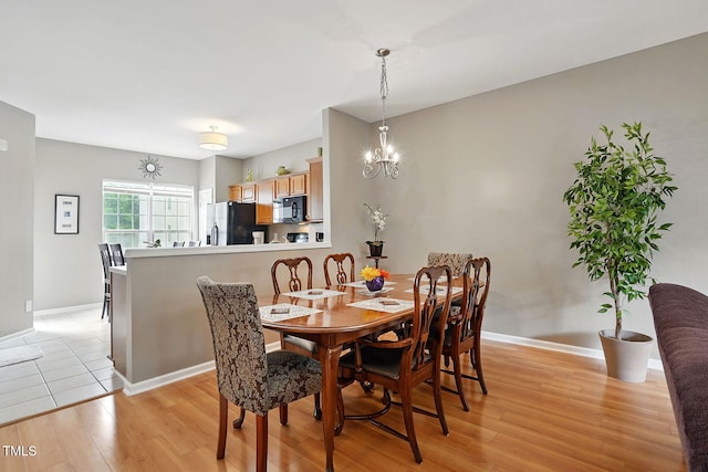 4907 Wyatt Brook Way, Raleigh, NC 27609 - dining room featuring light wood finished floors, a chandelier, and baseboards