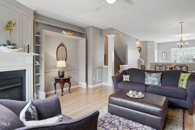 4907 Wyatt Brook Way, Raleigh, NC 27609 - living area featuring light wood-style flooring, a ceiling fan, a chandelier, and stairway
