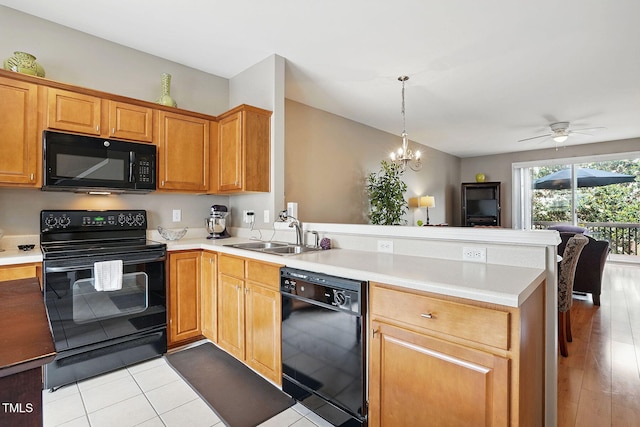 4907 Wyatt Brook Way, Raleigh, NC 27609 - kitchen with black appliances, a sink, a peninsula, light countertops, and open floor plan