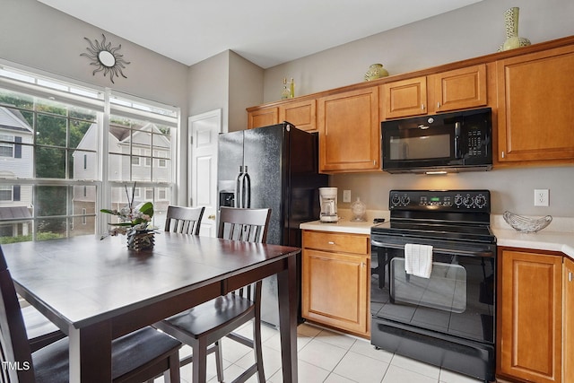 4907 Wyatt Brook Way, Raleigh, NC 27609 - kitchen featuring black appliances, light countertops, light tile patterned floors, and brown cabinetry