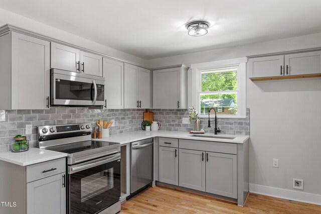 833 Brigham Rd, Raleigh, NC 27610 - kitchen featuring appliances with stainless steel finishes, gray cabinetry, a sink, and light countertops