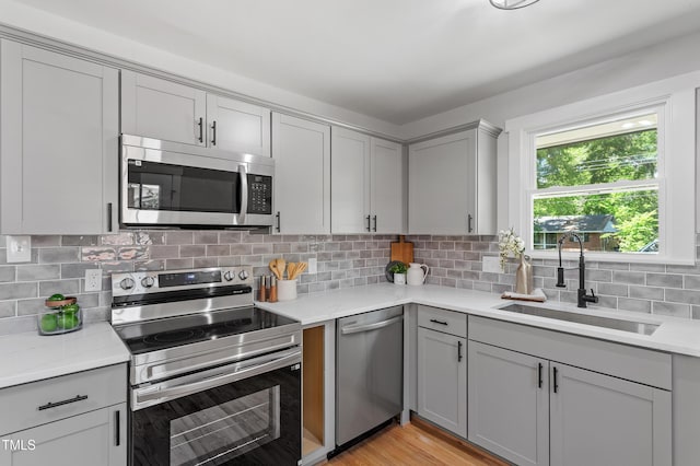 833 Brigham Rd, Raleigh, NC 27610 - kitchen featuring appliances with stainless steel finishes, a sink, gray cabinets, light countertops, and decorative backsplash
