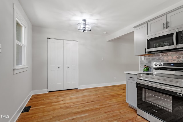 833 Brigham Rd, Raleigh, NC 27610 - kitchen with stainless steel appliances, baseboards, light wood-style floors, and decorative backsplash