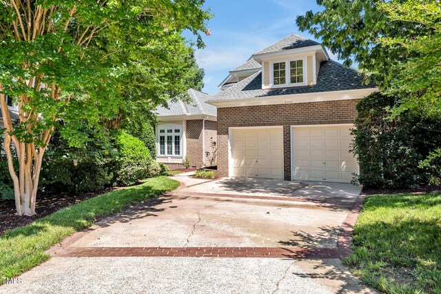 81002 Alexander, Chapel Hill, NC 27517 - view of front of house with brick siding, driveway, roof with shingles, and a garage
