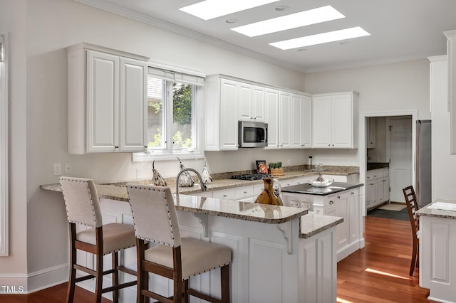 81002 Alexander, Chapel Hill, NC 27517 - kitchen featuring stainless steel appliances, a peninsula, ornamental molding, white cabinets, and dark wood finished floors