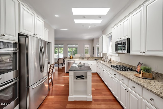 81002 Alexander, Chapel Hill, NC 27517 - kitchen featuring appliances with stainless steel finishes, light wood-type flooring, a skylight, white cabinetry, and crown molding
