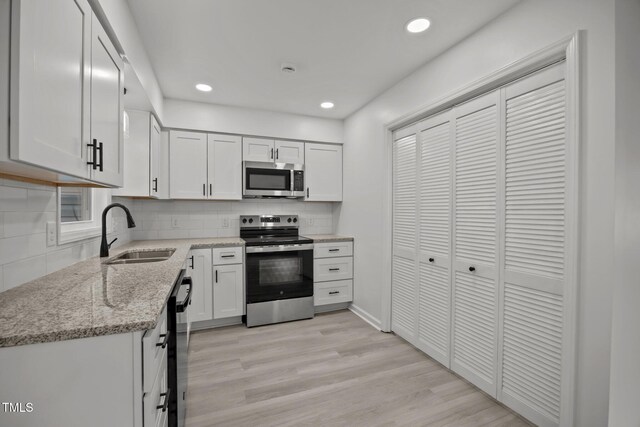 111 S Gaylee Lake Dr, Wendell, NC 27591 - kitchen with stainless steel appliances, a sink, decorative backsplash, light stone countertops, and recessed lighting