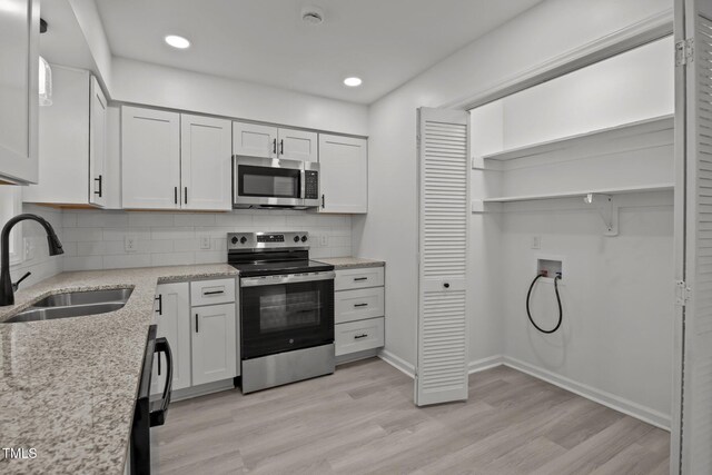 111 S Gaylee Lake Dr, Wendell, NC 27591 - kitchen featuring stainless steel appliances, a sink, open shelves, decorative backsplash, and light wood-style floors