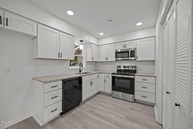 111 S Gaylee Lake Dr, Wendell, NC 27591 - kitchen with stainless steel appliances, a sink, white cabinetry, light wood-style flooring, and recessed lighting