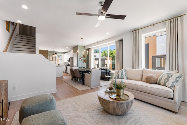 1408 Sawyer Rd Unit 103, Raleigh, NC 27610 - living room featuring light wood-style flooring, a chandelier, stairway, a ceiling fan, and recessed lighting