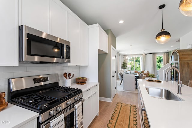 1408 Sawyer Rd Unit 103, Raleigh, NC 27610 - kitchen with appliances with stainless steel finishes, light countertops, white cabinets, tasteful backsplash, and light wood-style floors