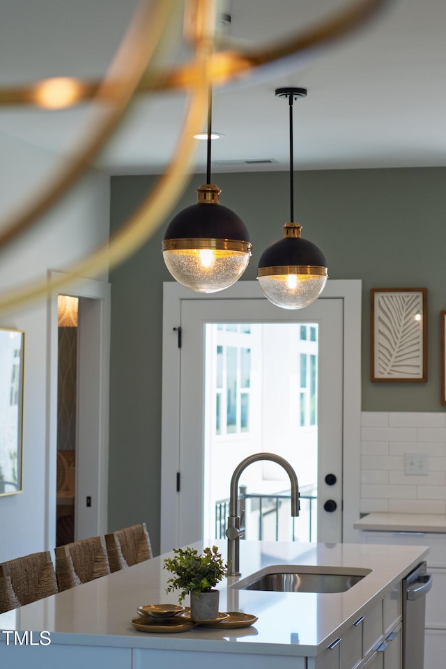 1408 Sawyer Rd Unit 103, Raleigh, NC 27610 - kitchen featuring pendant lighting, light countertops, decorative backsplash, and white cabinets
