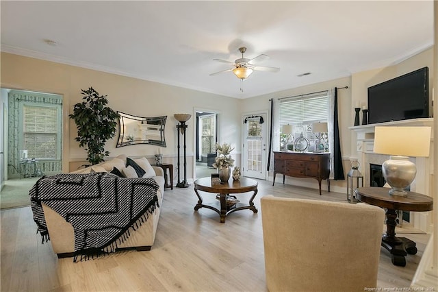159 Gallery Dr Unit 103, Spring Lake, NC 28390 - living room with ceiling fan, healthy amount of natural light, a glass covered fireplace, light wood-type flooring, and crown molding