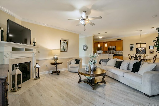 159 Gallery Dr Unit 103, Spring Lake, NC 28390 - living room with ceiling fan, light wood-style flooring, ornamental molding, a tile fireplace, and baseboards