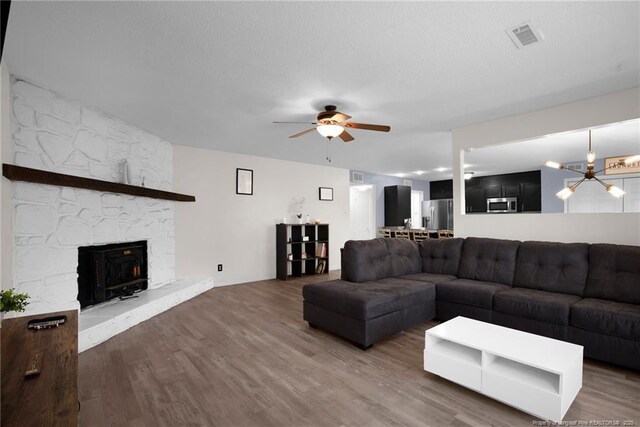 3855 Sturbridge Dr, Hope Mills, NC 28348 - living area featuring wood finished floors, ceiling fan, and a fireplace