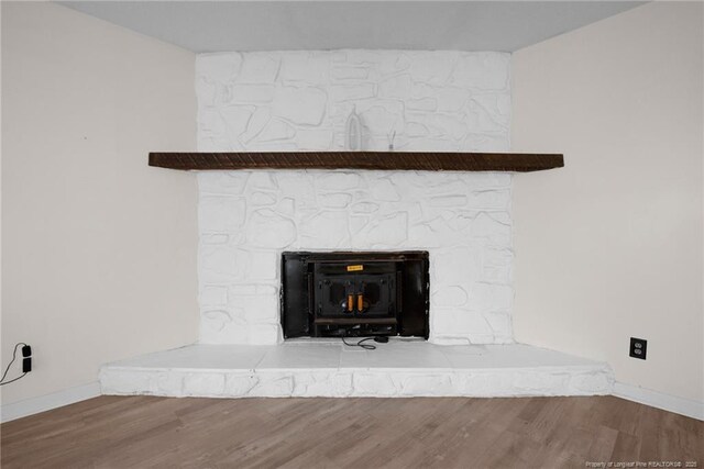 3855 Sturbridge Dr, Hope Mills, NC 28348 - detailed view of baseboards, a stone fireplace, and wood finished floors