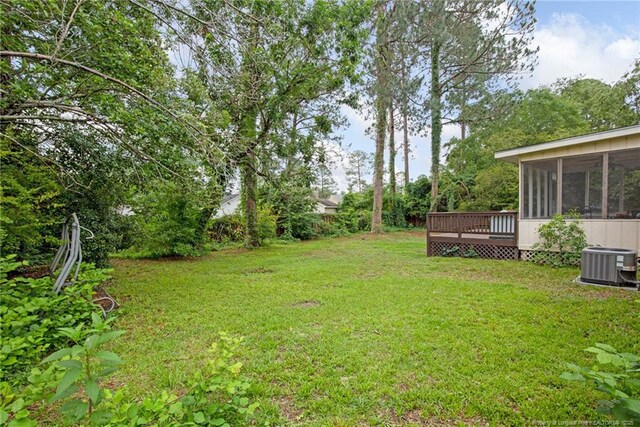3855 Sturbridge Dr, Hope Mills, NC 28348 - view of green lawn with central AC, a sunroom, and a wooden deck