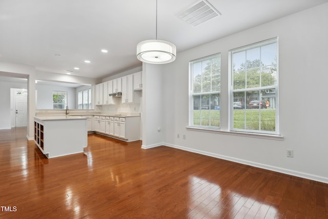 3141 Rapid Falls Rd, Cary, NC 27519 - kitchen with baseboards, light countertops, wood-type flooring, recessed lighting, and hanging light fixtures