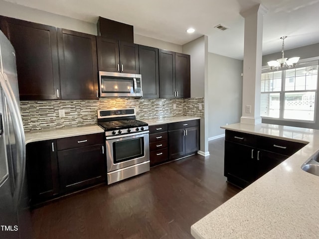 7241 Terregles Dr, Raleigh, NC 27617 - kitchen featuring appliances with stainless steel finishes, backsplash, dark wood-style flooring, baseboards, and a chandelier